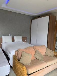 a bedroom with a large bed and a couch at Flat em Tropical executive Hotel in Manaus