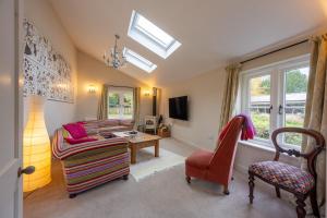 a living room with a couch and a chair at The Pottage in Hoxne +15 photos