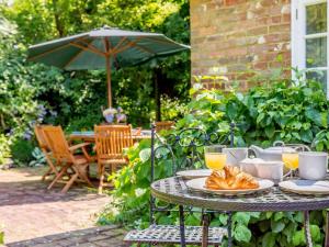a table with a plate of croissants and an umbrella at 5 Bed in Rye 82395 in Peasmarsh