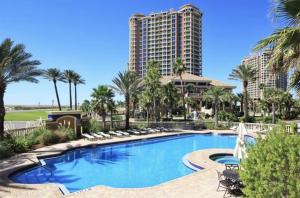 einen Pool in einem Resort mit Palmen und einem Gebäude in der Unterkunft Portofino Island Resort 1-1306 in Pensacola Beach