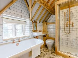 a bathroom with a tub and a toilet at 1 Bed in Longborough 82284 in Longborough