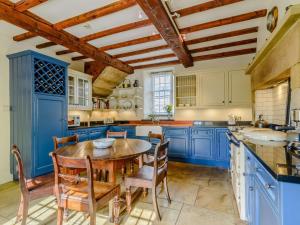 a blue kitchen with a wooden table and chairs at 5 bed in Pateley Bridge 83663 in Summer Bridge