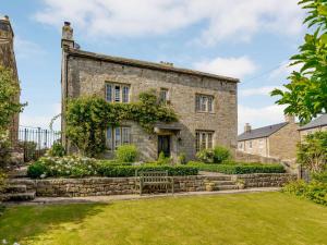 an old stone house with a garden in front of it at 5 bed in Pateley Bridge 83663 in Summer Bridge