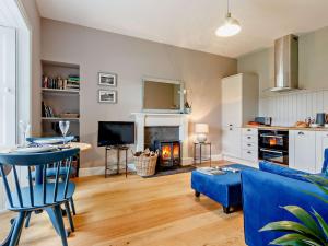 a living room with a blue couch and a fireplace at 1 Bed in Crieff 85244 in Crieff