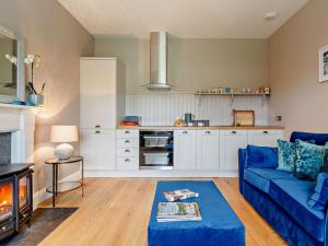 a living room with a blue couch and a kitchen at 1 Bed in Crieff 85244 in Crieff