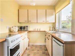 a kitchen with white appliances and a window at 1 Bed in Kirkby-in-Furness SZ463 in Grizebeck