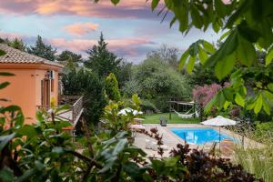 a backyard with a swimming pool and a house at Maison Christine Villa in Varnávas