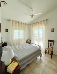 a bedroom with a bed and a table with a lamp at Tra Cielo e Mare - Spiaggia San Lorenzo in Reitani