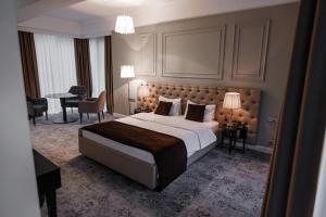 a bedroom with a large bed and a table and chairs at Time Hotel&SPA in Chişinău