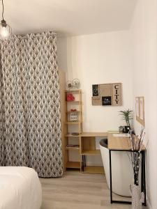 - une chambre avec un lit, un bureau et un rideau dans l'établissement Charmant et moderne de L’Hay, à Chevilly-Larue