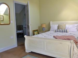 a bedroom with a white bed and a mirror at Finest Retreats - No 2 Meynell Mews in Breedon on the Hill