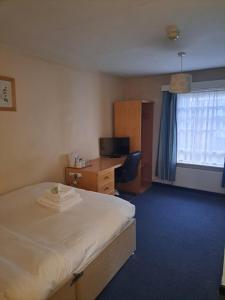 a hotel room with a bed and a desk and a window at Luther King House in Manchester