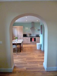 a kitchen with an archway with a table in it at Finest Retreats - No 2 Meynell Mews in Breedon on the Hill