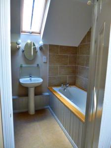 a bathroom with a sink and a tub and a window at Finest Retreats - No 2 Meynell Mews in Breedon on the Hill