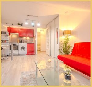 salon z czerwoną kanapą i kuchnią w obiekcie Studio / Chaleureux / Marignier w mieście Marignier
