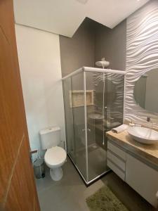 a bathroom with a shower and a toilet and a sink at Villa dos Diamantes 35 Bahia in Porto Seguro