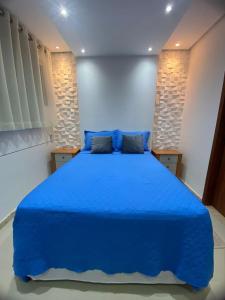 a bedroom with a blue bed with blue sheets at Villa dos Diamantes 35 Bahia in Porto Seguro