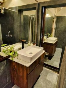 uma casa de banho com um lavatório branco e um espelho. em The Turquoise Letterbox - Loft suite at Central em Calcutá