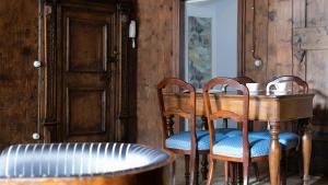 een tafel met 2 stoelen en een houten tafel met bij Roma 34 in Bormio