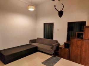 een woonkamer met een bank en een tv bij The Turquoise Letterbox - Loft suite at Central in Calcutta