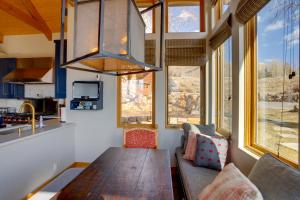 uma sala de estar com uma mesa de madeira e algumas janelas em Telluride Mountain Chalet with Gym, Hot Tub and Views! em Telluride