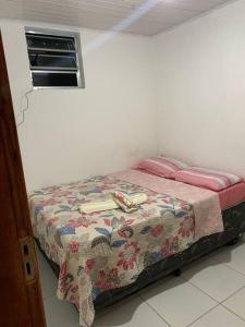 a small bed in a room with avertisement at Casa próximo ao aeroporto in Rio Largo