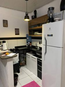 a kitchen with a white refrigerator in a room at Casa próximo ao aeroporto in Rio Largo