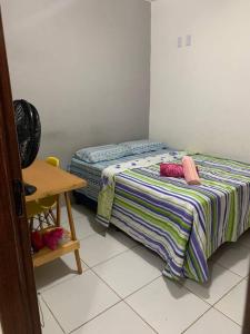 a small bedroom with a bed and a table at Casa próximo ao aeroporto in Rio Largo