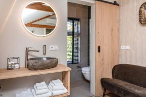 uma casa de banho com um lavatório e um espelho em B&B De Mansarde em Apeldoorn
