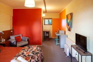 a room with a bedroom with a bed and a tv at Treetops Silvan Valley Lodge - suite 1 in Silvan