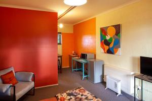 a living room with a couch and a desk in a room at Treetops Silvan Valley Lodge - suite 1 in Silvan