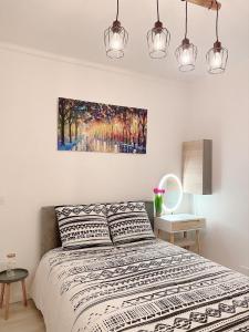 a bedroom with a bed and a painting on the wall at Charmant et moderne de L’Hay in LʼHay-les-Roses
