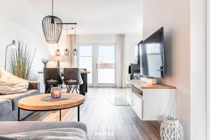 un salon avec un canapé et une table avec une télévision dans l'établissement Strandläufer Büsum, à Büsum