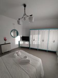 1 dormitorio con 1 cama blanca grande y espejo en Vivienda turística María de Padilla, en Montiel