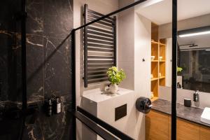 Apartament Zoom na Giewont by Apart Concept Podhale في كوشتيليسكا: حمام مع إناء من الزهور على منضدة +43 صورة