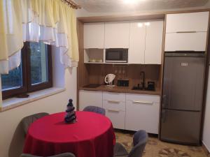 a kitchen with a red table in a room at Czesławka in Zawoja