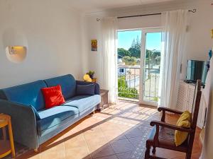 een woonkamer met een blauwe bank en een televisie bij Apartamento Bela Vista, panoramic ocean view in Porches