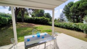 a table with blue glasses on it on a patio at Appartamento Cod 466 - Taunus Vacanze in Numana