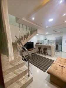a living room with a staircase and a kitchen at Villa dos Diamantes 35 Bahia in Porto Seguro