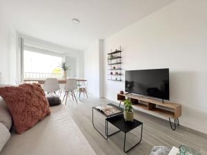 uma sala de estar com um sofá e uma televisão de ecrã plano em Apartamentos Gredos 202 em Jaraíz de la Vera