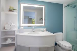a bathroom with a white sink and a mirror at Sanibel Island Beach Resort in Sanibel