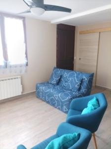 a living room with a blue couch and a chair at patrice et chrstel Appartement indépendant in Les Malossannes +3 photos