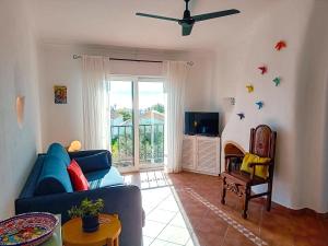 a living room with a blue couch and a tv at Apartamento Bela Vista, panoramic ocean view in Porches