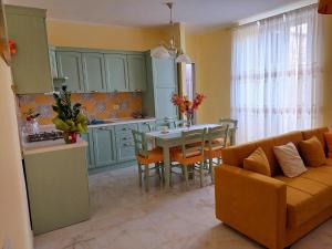 a kitchen and dining room with a couch and a table at maison charlotte in Bagnaia
