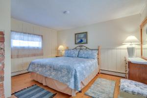ein Schlafzimmer mit einem blauen Bett und einem Fenster in der Unterkunft Cozy New Hampshire Cottage with Deck, Near Skiing! in Glen