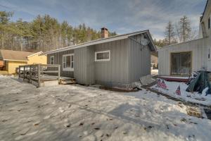 ein Haus im Schnee vor einem Haus in der Unterkunft Cozy New Hampshire Cottage with Deck, Near Skiing! in Glen