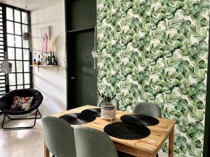 a dining room table with chairs and a green wallpaper at Cozy Vacation Home -San Juan -Centric location in San Juan