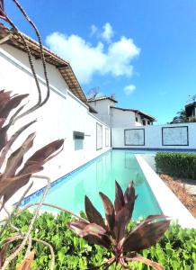 a swimming pool in a house with plants at Villa dos Diamantes 35 Bahia in Porto Seguro