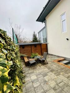 a patio with a table and chairs next to a house at Urban escape #12lunipebega in Timişoara