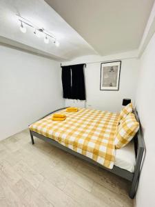 a bedroom with a bed with a plaid blanket at Urban escape #12lunipebega in Timişoara